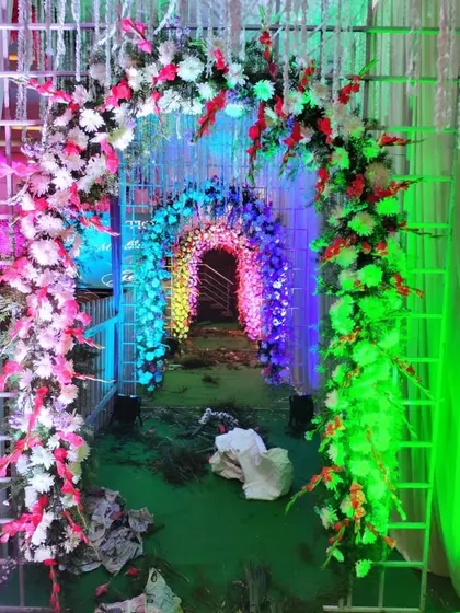 A rainbow-lit floral tunnel entrance, creating a vibrant and exciting pathway for guests as they arrive at the event.