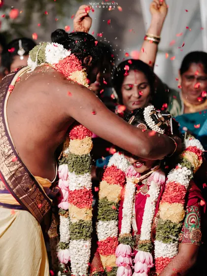 The moment of tying the mangalsutra, captured with a shower of petals. This action shot freezes a moment of pure celebration and tradition.