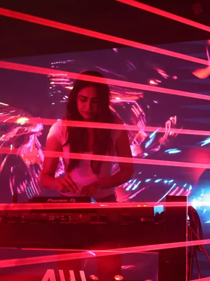 An artistic shot of me performing at Ibiza, Jhansi, with red laser beams creating a web of light. This shows how I use lighting to create a futuristic and immersive atmosphere.