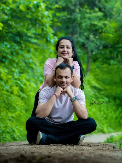 A fun and creative pose for a pre-wedding shoot. This playful setup on a forest path makes for a unique and memorable couple's photo.