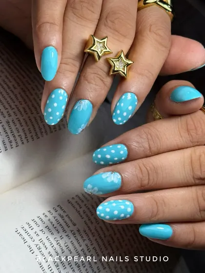 A classy and trendy design featuring aqua blue polish with polka dots and soft, hand-painted flowers. This set combines a popular pattern with delicate art for a look of pure elegance.
