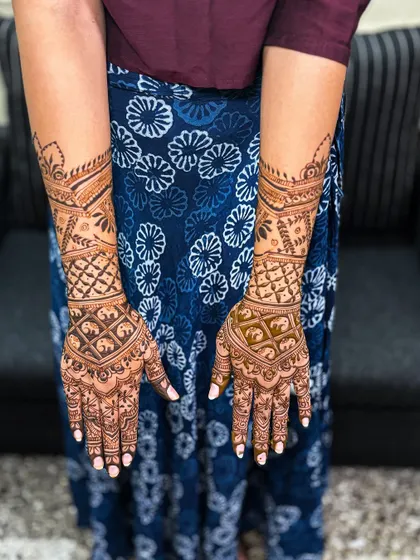 The back of Nayana's hands, showcasing a different but complementary design that completes her bridal look.