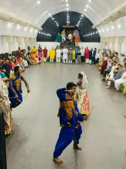 A Garba performance for a pre-wedding event. The guests are seated in a circle, creating an intimate and interactive setting for the dancers.