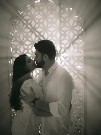 A tender kiss framed by dramatic light rays, turning a simple moment into a piece of fine art.