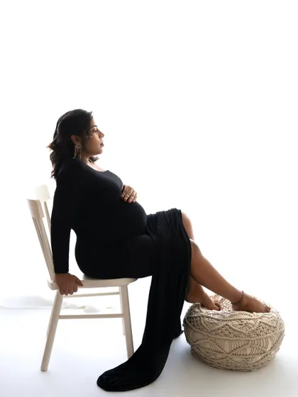 A seated pose that is both regal and relaxed. The long black gown drapes beautifully, creating a portrait that is full of grace and confidence.