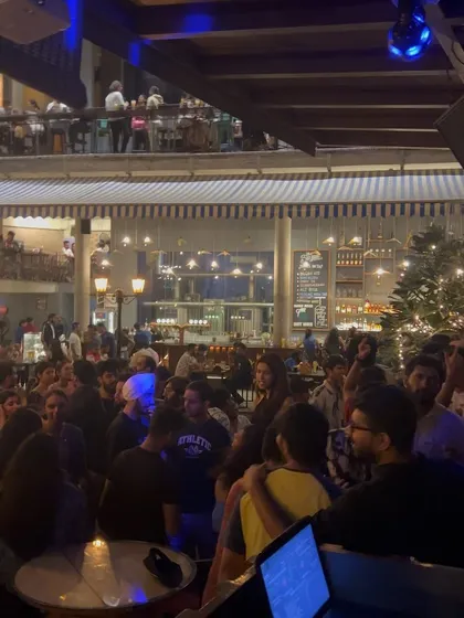 A wider angle of the party at The Bier Library. You can see people enjoying themselves across the entire venue, from the dance floor to the upper levels.