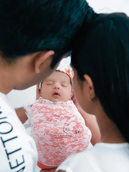A beautiful, intimate moment between new parents and their precious baby. This over-the-shoulder shot creates a sense of privacy and deep connection.