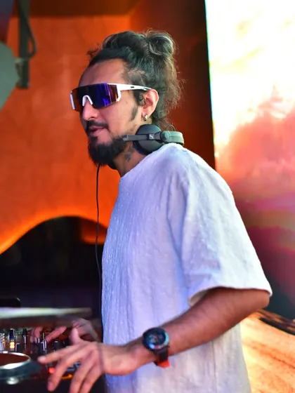 In the zone, mixing tracks while the VJ screen displays a beautiful sunset visual, perfectly matching the mood of the music.