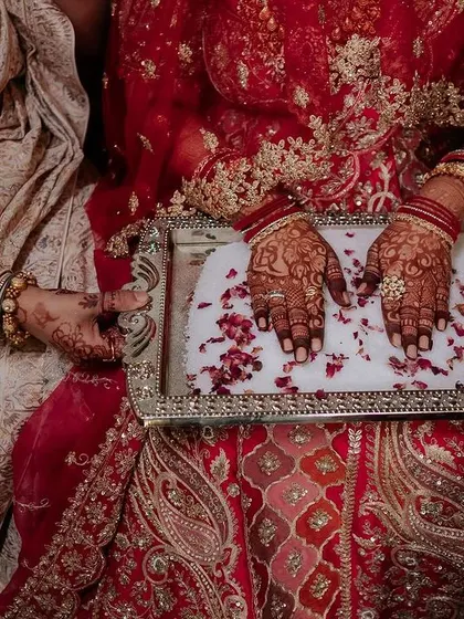A regal bride in her magnificent red lehenga. We capture the grandeur of the bridal attire, creating portraits that are both powerful and elegant.
