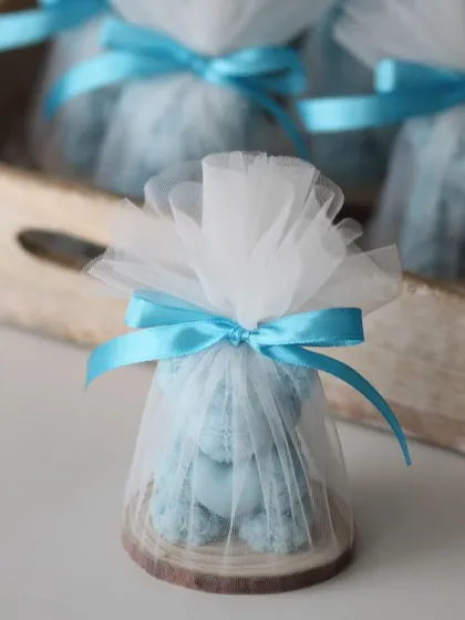 A blue Rose Bear candle, wrapped in a net potli. This is a great favor for a baby boy's shower or birthday.