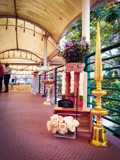 An entrance decor detail from a traditional ceremony. The combination of wooden crates, fresh flowers, and ornate brass decor creates a warm and welcoming entryway for guests.