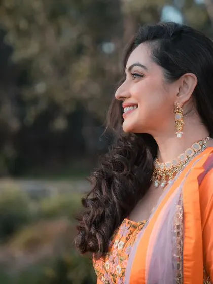 A beautiful, sun-kissed shot of a model in a vibrant orange Anarkali.