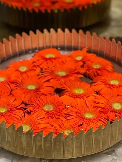 Styling with Urlis adds to the beauty of an entire setup. This brass urli filled with floating orange gerbera daisies creates a simple yet stunning piece of decor for any festive table.