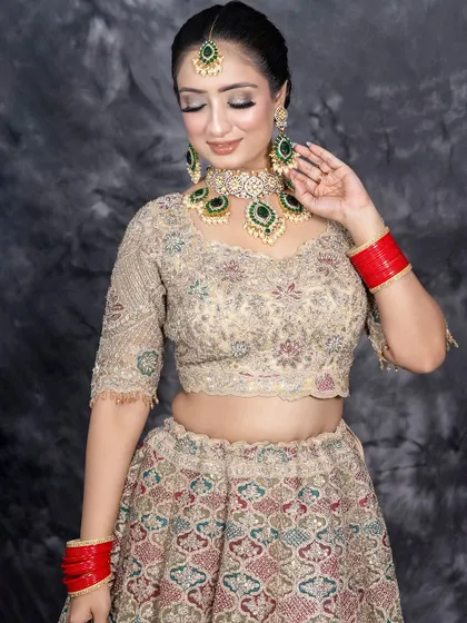 A full-length view of this gorgeous bridal lehenga. The makeup is designed to complement the outfit's intricate embroidery, with a focus on shimmering eyelids and a natural, glowing complexion.