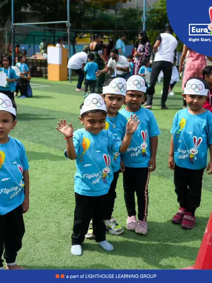 Ready, set, go. A group of our young athletes wave before their race, wearing their team shirts and Olympic-style hats, full of excitement for the day's events.