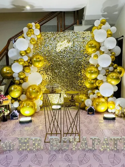 A wide view of the gold and white themed decor, showing how it can be set up in a home environment, utilizing the space under a staircase for a grand effect.