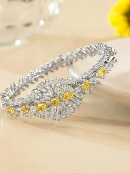 A close-up hero shot of a stunning bracelet from Nanagram Jewels. The soft focus background and delicate styling with yellow flowers draw all the attention to the intricate design and sparkle of the piece.