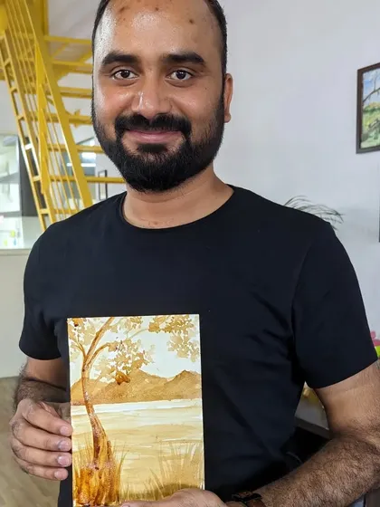 A participant holding his beautiful coffee painting, another one of the many art forms we explore.
