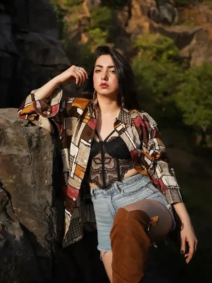Adding knee-high boots to the shorts and shirt combo for an edgier, more fashionable look. This photo is all about confident styling.