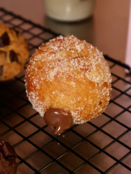A close-up of a Nutella-filled bomboloni, with a little bit of the chocolatey goodness peeking out.