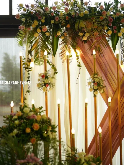 A closer look at the lighting and floral details from the peach drape stage. You can see how the warm lights and hanging bouquets with palm leaves add a touch of tropical elegance to the overall design.