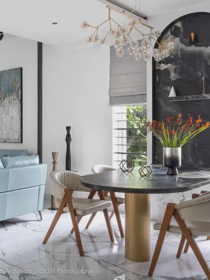 A complete view of the open-plan living and dining area. The space is tied together by white marble flooring with grey veins, creating a bright and luxurious foundation for the curated furniture and decor.