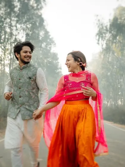 A joyful and colorful pre-wedding photo of a couple running down a country road. We love capturing the energy and happiness of our couples in beautiful natural settings.