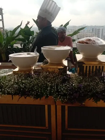 Our live counters are not just for chaat. This setup, with a stunning city view in the background, features a chef preparing dishes for a corporate party, showcasing our versatility.