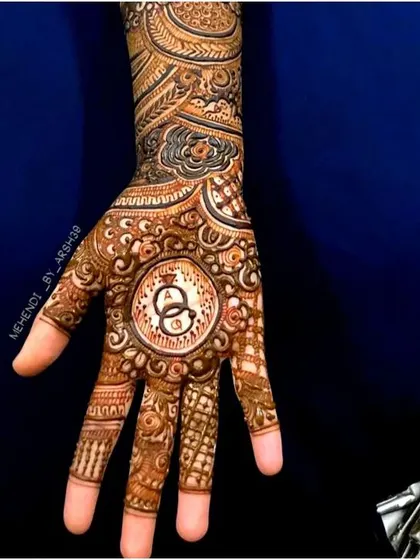 I love creating custom designs that tell your story. This engagement henna features the couple's initials, 'A' and 'Q', inside a central mandala with interlocking rings, symbolizing their union.