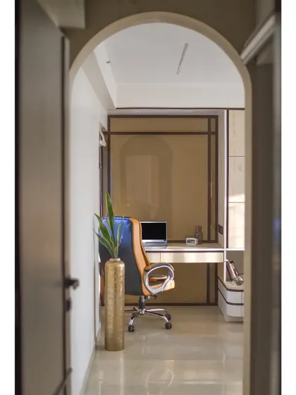 A view through an arched doorway into the home office. The use of arches creates a sense of flow and visual continuity throughout the home.