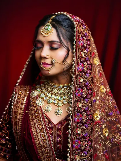 The bride is draped in a heavily embroidered dupatta, and the makeup by our student stands out with its rich colors and flawless application.