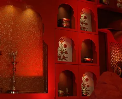 Hand-painted vases and traditional brass lamps are placed in artfully designed niches, adding layers of detail to the temple-inspired wedding decor.
