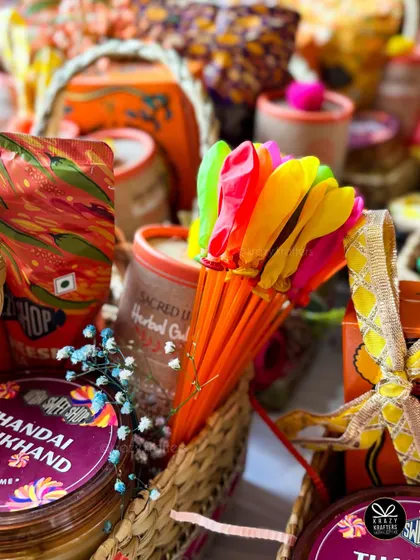 A close-up of our Holi baskets, featuring Thandai Shrikhand, herbal gulal, and colorful water balloons.