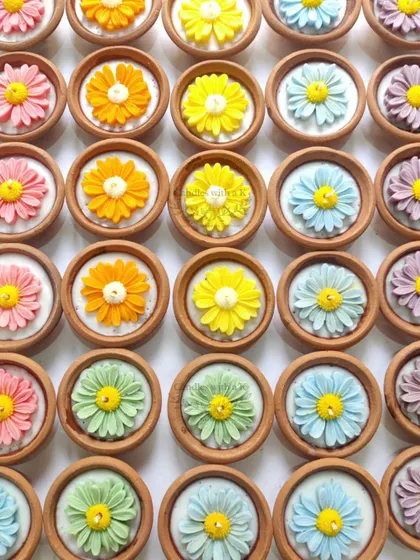 An overhead view of the colorful daisy clay pot candles, a cheerful and rustic option for Diwali gifts.