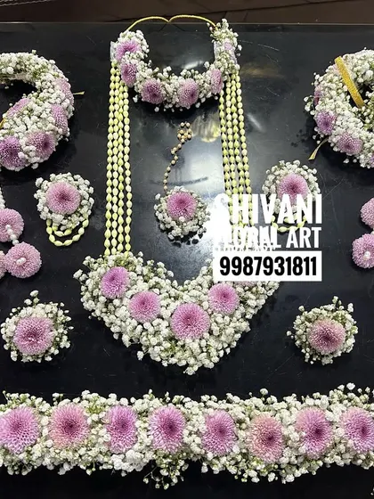 Here is a complete baby shower jewellery set, ready to be worn. This design features a beautiful combination of baby's breath and soft pink flowers, including a necklace, maang tikka, earrings, hand pieces, and a matching kamarbandh.