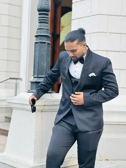 A moment of reflection. This groom looks incredibly sharp in a classic black tuxedo, showcasing the timeless appeal of a well-fitted suit.
