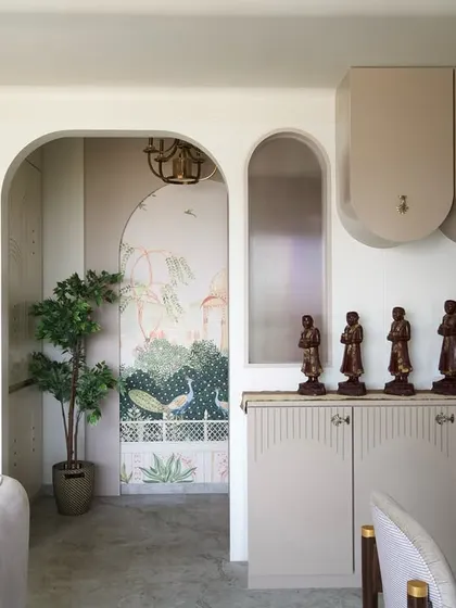 Arches frame this beautiful corner in the 'Vrindavan' home, where a peacock mural adds a touch of traditional artistry. It's a celebration of heritage within a modern, neutral setting.