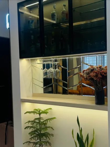 A closer look at the passage bar unit, highlighting the custom wine glass holder and the reflective mirror that adds a touch of glamour.
