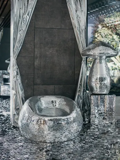 A shimmering silver chair and mirrored mushroom sculpture at 'The Melting Disco Ball'. Guests were greeted by a path of silver confetti, setting the stage for a night that defied the rules and celebrated the rebels.