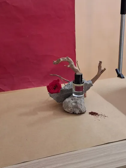 A close-up of the styling process, arranging the driftwood, stone, and flower for the Fraganote shoot.