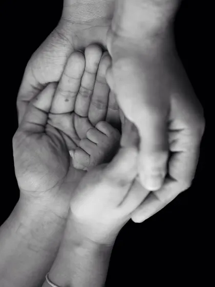 Little things that aren't really little. A beautiful black and white photo showing the hands of the whole family coming together around the baby's.