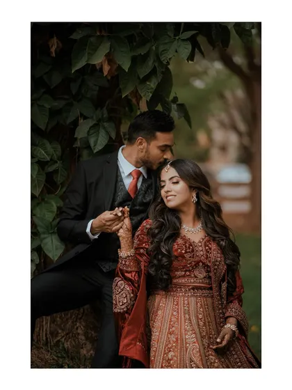 A tender moment with the groom kissing the bride's forehead.