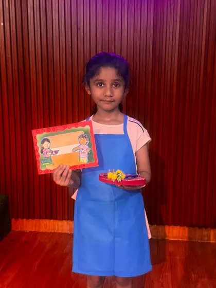 A student shows off her handmade Rakshabandhan card and thali. In this workshop, kids learn to create personalized gifts, making the festival of siblings even more special.