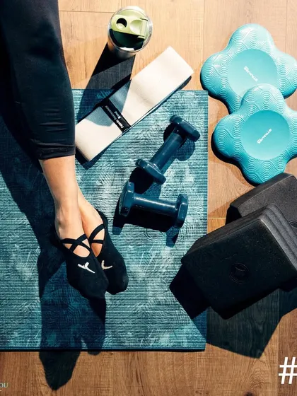 A flat lay of some of the equipment we use in class, including dumbbells, resistance bands, stability cushions, and Pilates socks. We have everything you need for a varied and effective workout.