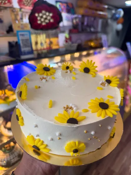 A cheerful sunflower-themed cake. The bright yellow fondant sunflowers are handcrafted and arranged beautifully on a simple white cake, bringing a ray of sunshine to any celebration.