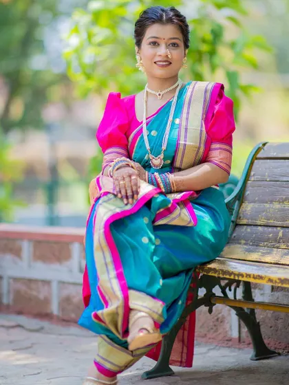 The full view of this elegant look, featuring a soft textured bun and a beautifully draped Nauvari saree. The hairstyle is comfortable yet sophisticated, perfect for enjoying the day's events.