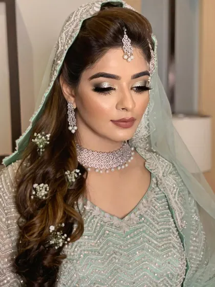 This angle highlights the beautiful side-swept hair with baby's breath, which adds a romantic touch to the overall look.