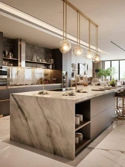 A stunning open-plan kitchen with a large marble island that doubles as a dining area. The dark cabinets and gold accents create a look of pure luxury and sophistication.