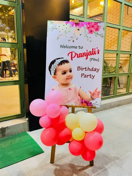 A personalized welcome easel sign for a birthday party. This small detail, decorated with balloons, adds a special touch for guests as they arrive.
