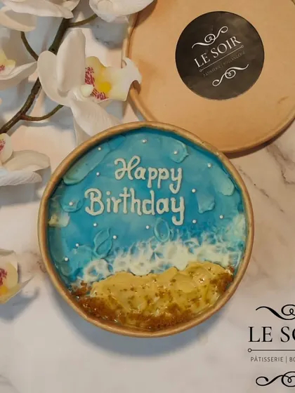 I can bring the beach to you with this ocean-themed cake tub. It features buttercream waves, crushed biscuit sand, and a "Happy Birthday" message, perfect for anyone who loves the sea.